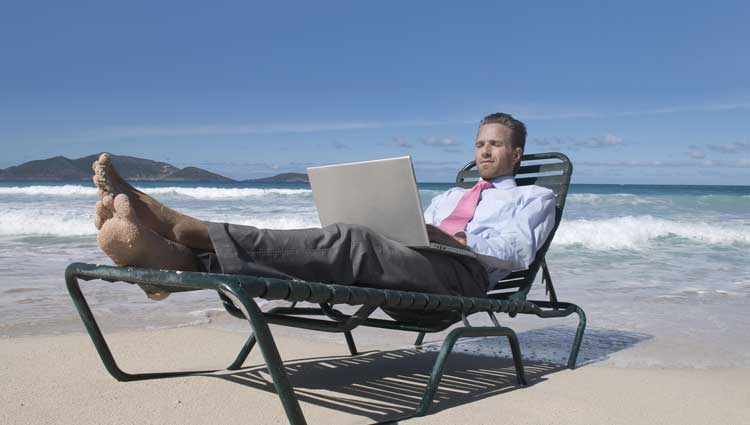 Man working at beach in office attire