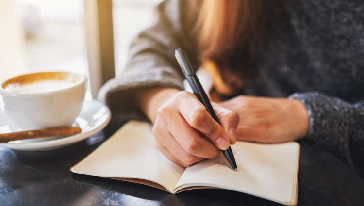 An image of a woman journaling and writing for growth.